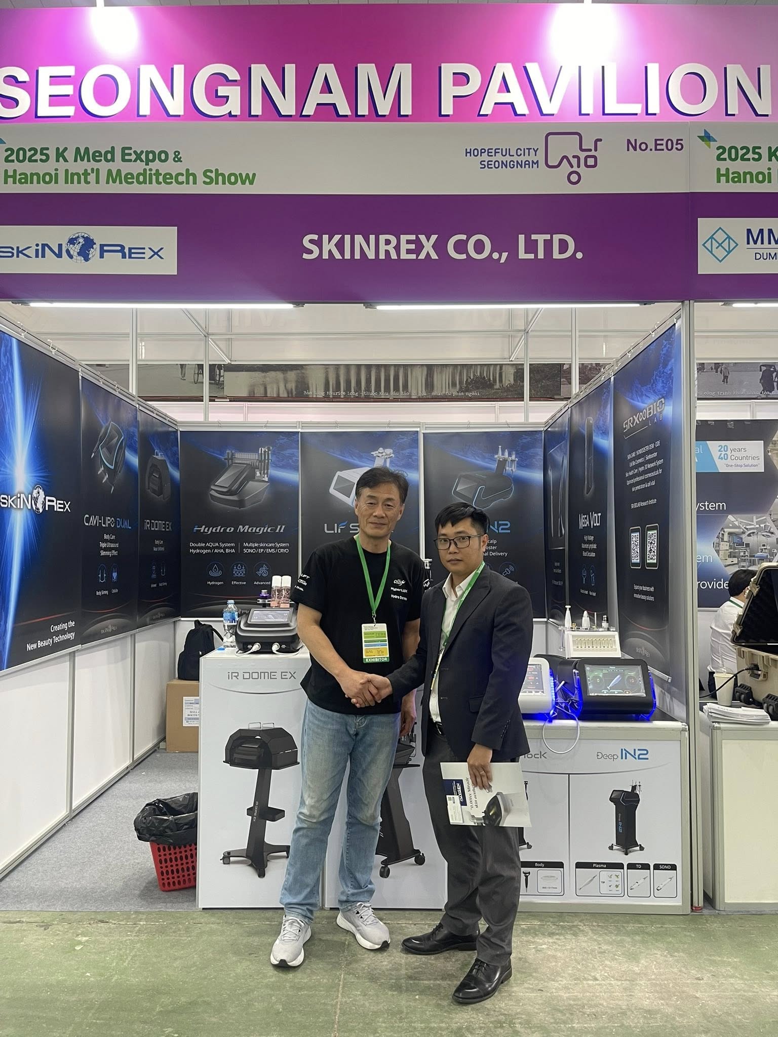 Hai người đàn ông bắt tay tại gian hàng Skinrex Co Ltd trong triển lãm thiết bị y tế Seongnam Pavilion